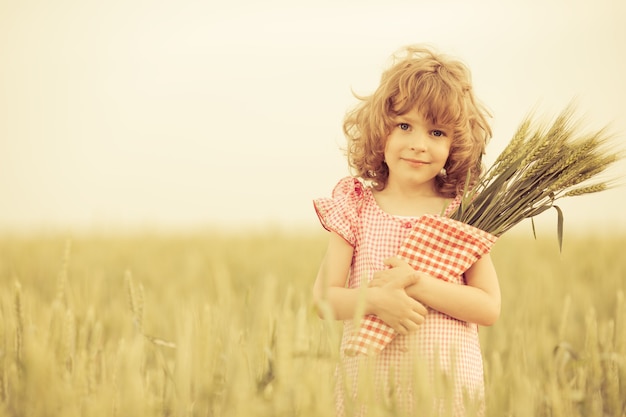 Szczęśliwe dziecko w jesiennym polu pszenicy