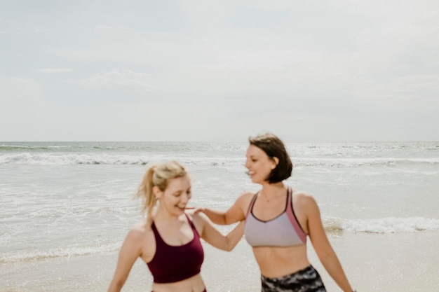 Szczęśliwe kobiety rozciągające się na plaży