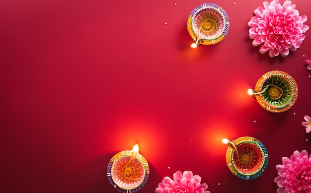 Szczęśliwe lampy Diwali Clay Diya zapalają się podczas Diwali Hinduskiego festiwalu świateł celebracji Kolorowa tradycyjna lampa naftowa diya na czerwonym tle