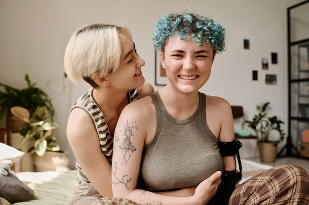 Szczęśliwe lesbijki obejmujące się podczas spędzania czasu w pokoju