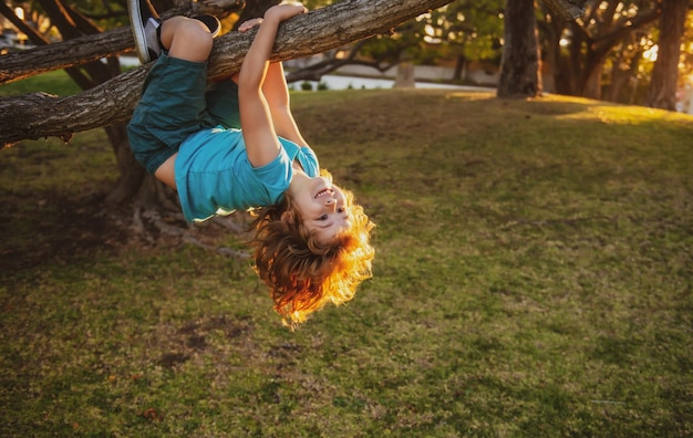 Szczęśliwe małe dziecko cieszące się letnim dniem w ogrodzie Słodkie dziecko wspinające się na drzewo