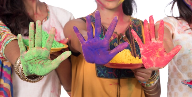 Zdjęcie szczęśliwe młode dziewczyny zabawy z kolorowym proszkiem na festiwalu kolorów holi