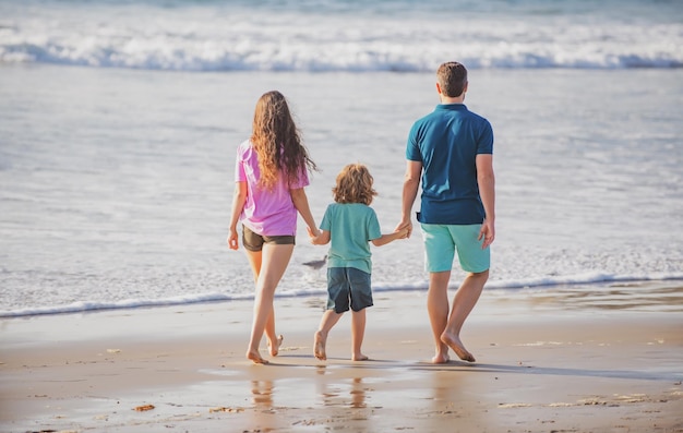 Szczęśliwe rodzinne wakacje Radosny ojciec matka syn spacer nad morzem piasek plaża Aktywni rodzice i ludzie aktywność na świeżym powietrzu na letnie wakacje z dziećmi Koncepcja rodzinnych zajęć rekreacyjnych