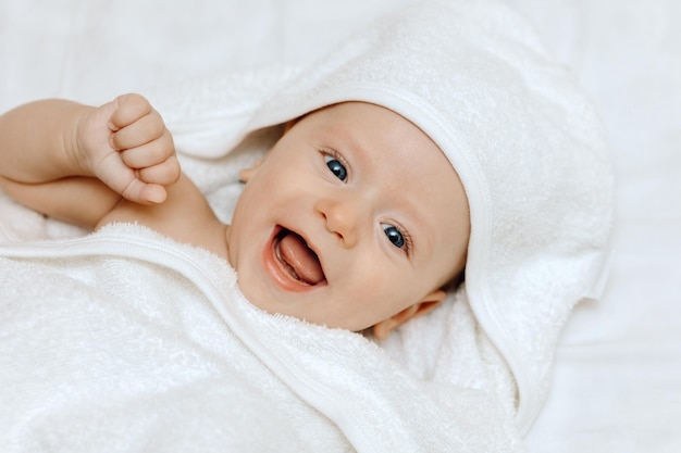 Szczęśliwe uśmiechnięte dziecko w ręczniku po kąpieli portret szczęśliwego dziecka