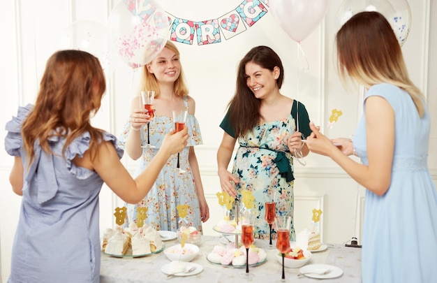Szczęśliwe, wesołe kobiety świętujące razem podczas gatunku ujawniają imprezę na tle balonów
