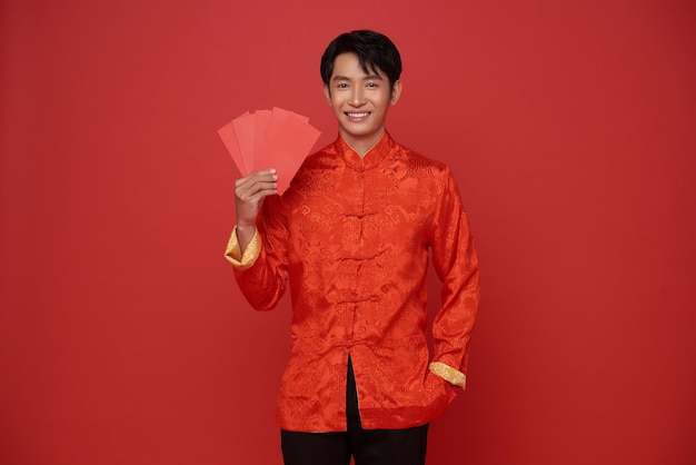 Szczęśliwego chińskiego Nowego Roku Azjat trzymający angpao lub czerwoną paczkę darów pieniężnych