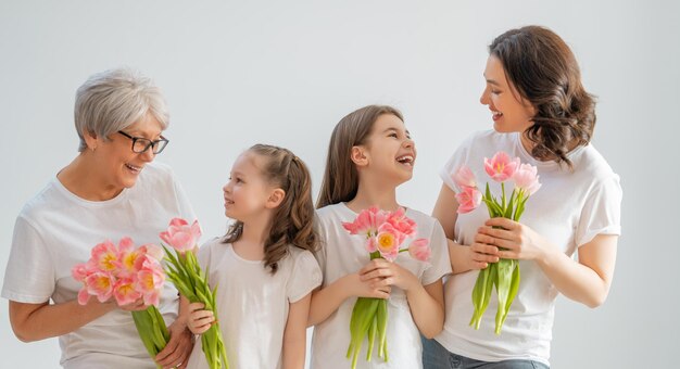 Szczęśliwego dnia kobiet Córki dzieci gratulują mamie i babci, dając im kwiaty tulipanów