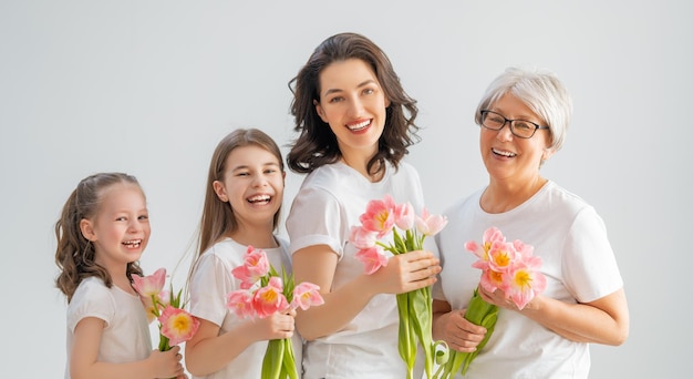 Szczęśliwego dnia kobiet Córki dzieci gratulują mamie i babci dając im kwiaty tulipanów