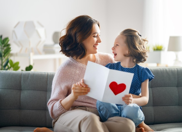 Szczęśliwego dnia matki Córka gratuluje mamie i daje jej pocztówkę Mamo