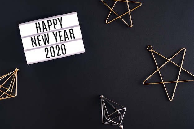 Szczęśliwego nowego roku 2020 party light box z gwiazdą ozdoba element widok z góry na stole czarne tło