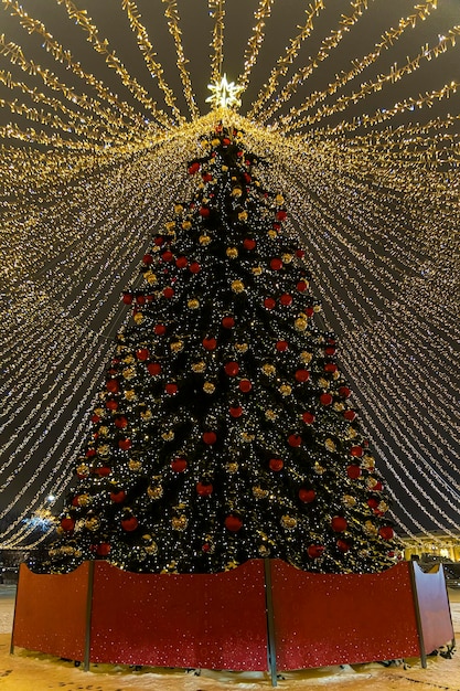 Szczęśliwego Nowego Roku i Święta Bożego Narodzenia Piękna, malowniczo udekorowana choinka z dekoracjami i oświetlona lekkimi girlandami