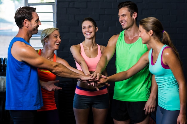 Szczęśliwi atlety stawia ręki w gym wpólnie