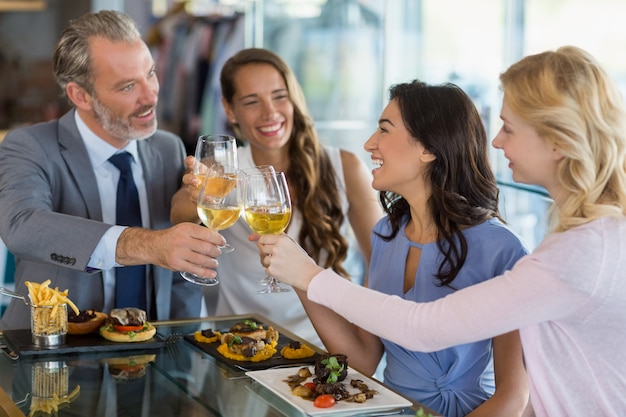 Szczęśliwi biznesowi koledzy wznosi toast piwnych szkła podczas gdy jedzący lunch
