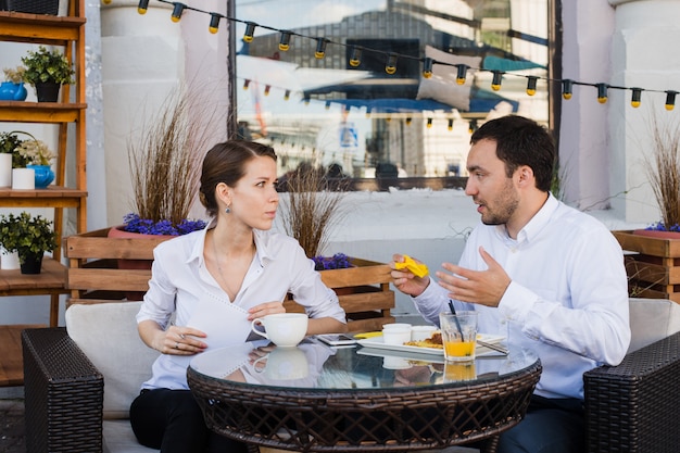 Szczęśliwi ludzie biznesu na lunchu na zewnątrz w kawiarni