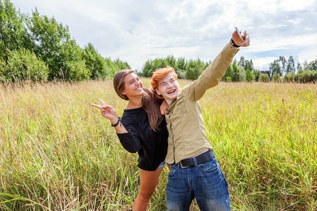 Zdjęcie szczęśliwi ludzie kochający para na zewnątrz szczęśliwy młody człowiek robi romantyczne selfie z dziewczyną