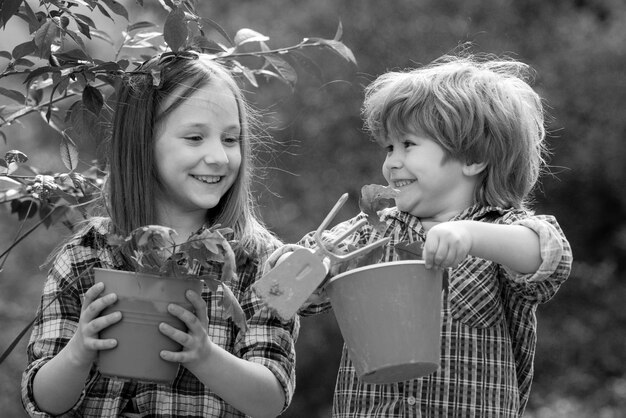 Zdjęcie szczęśliwi mali rolnicy bawiący się na polu brat i siostra bawią się razem w ogrodzie happy val