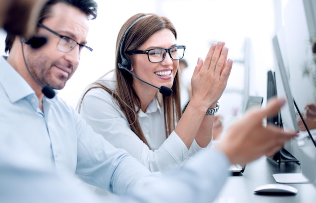 Szczęśliwi pracownicy call center siedzący przy biurku