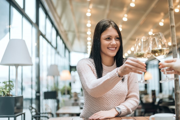 Szczęśliwi przyjaciele szczęk szklanek wina w restauracji.