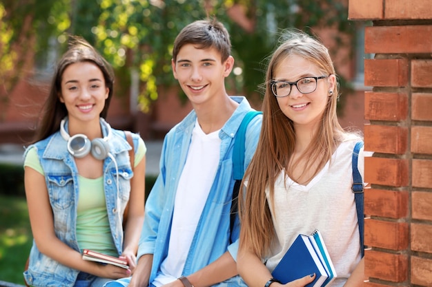 Zdjęcie szczęśliwi studenci z książkami na zewnątrz