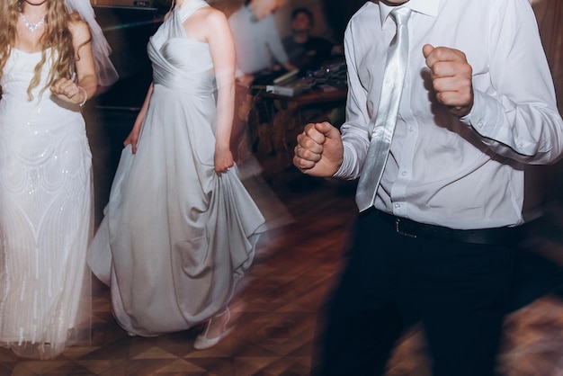 Zdjęcie szczęśliwi stylowi ludzie tańczą i bawią się na przyjęciu weselnym w gościach restauracji tańczących w lekkich ludziach w ruchu na imprezie w klubie