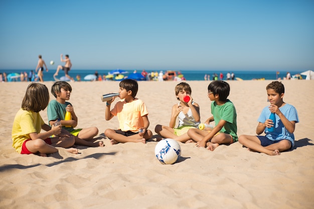 Szczęśliwi wieloetniczni przyjaciele preteen boy na plaży