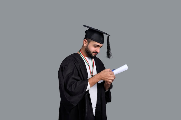 Szczęśliwy absolwent posiadający dyplom w ręku indyjski model pakistański