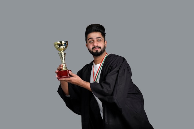 Szczęśliwy absolwent posiadający złote trofeum indyjski model pakistański