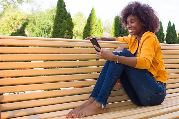 Szczęśliwy African American kobieta na ulicy rozmawia przez telefon