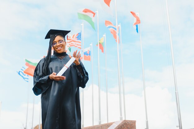 Szczęśliwy Afroamerykanin studentka z dyplomem na ukończeniu studiów