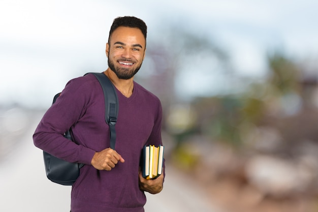 Szczęśliwy amerykanina afrykańskiego pochodzenia studenta collegu portret odizolowywający