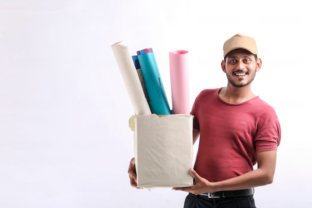 Szczęśliwy Azjatycki Człowiek W T-shirt I Czapka, Trzymając Pudełko Kolor Papieru Na Białym Tle Nad Białym Tle, Koncepcja Usługi Dostawy