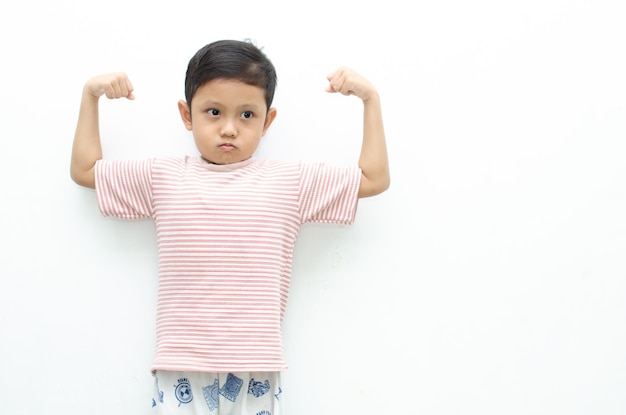 szczęśliwy azjatycki mały chłopiec pozujący gest tak z podniesieniem pięści pokazuje, że dorasta i jest silny