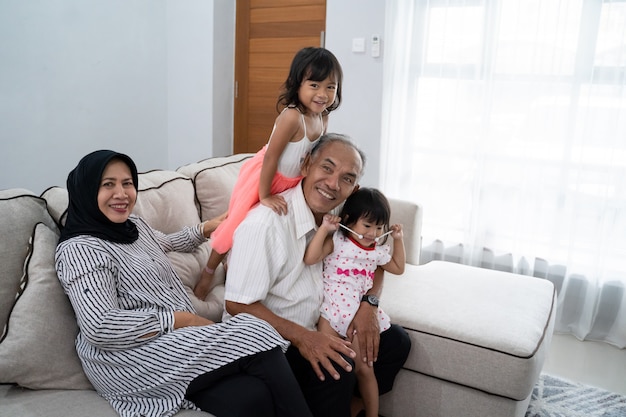 Szczęśliwy azjatykci muzułmański dziadek z wnukami w domu