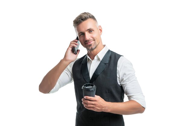 Szczęśliwy biznesmen opowiada na telefonie komórkowym podczas kawowej przerwy odizolowywającej na bielu