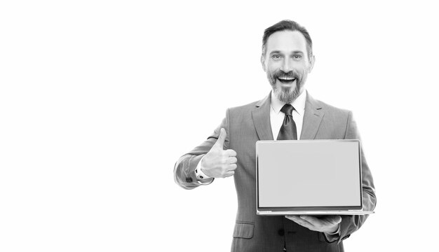 Szczęśliwy biznesmen prezentujący laptopa na miejsce na kopię miejsca na kopię pokazuje kciuk w górę propozycji produktu