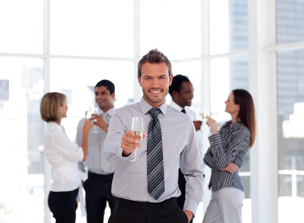 Szczęśliwy business manager trzyma szkło z jego drużyną