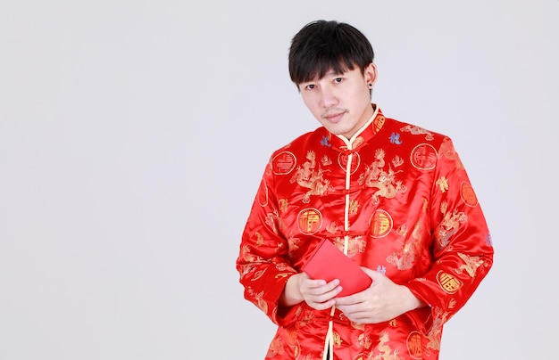 Szczęśliwy Chińczyk na tradycyjnej koszuli mandarynki uśmiech i radość z otrzymania kulturalnego prezentu pieniężnego w czerwonych kopertach na szczęśliwe święto pomyślności na nowy rok księżycowy