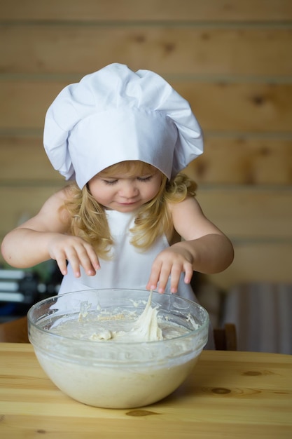 Szczęśliwy chłopiec dziecko gotuje wyrabianie ciasta