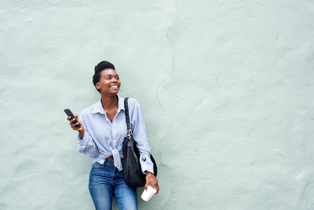 Szczęśliwy czarny kobiety mienia telefon komórkowy
