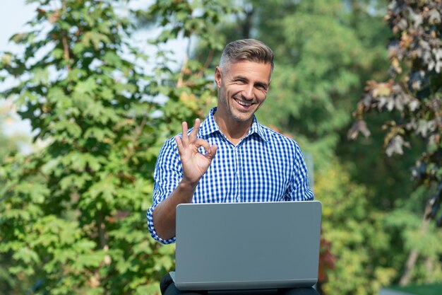 Szczęśliwy człowiek pracujący online freelancer pracujący online na świeżym powietrzu blog biznesowy