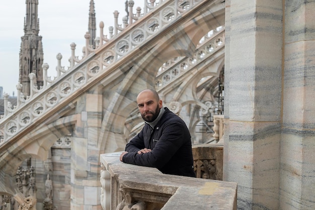 Zdjęcie szczęśliwy człowiek przed katedrą duomo w mediolanie