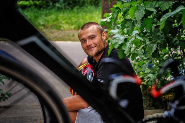 Szczęśliwy Człowiek Siedzący Na Schodach Z Rowerem Sportowym Przed Nim.
