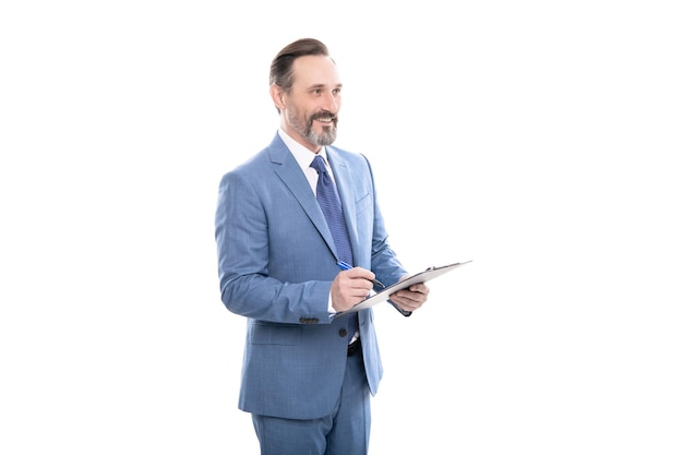 Szczęśliwy dojrzały mężczyzna w garniturze robi notatki lub podpisuje umowę na dokumentach w folderze na białym, robiąc notatki