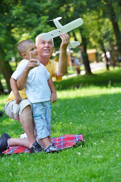 Zdjęcie szczęśliwy dziadek i dziecko bawią się i bawią w parku