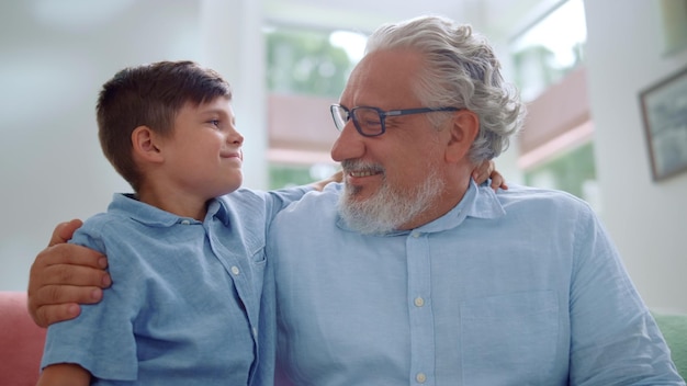 Szczęśliwy dziadek i wnuk przytulają się razem w salonie