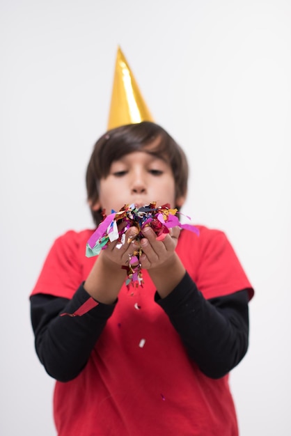 Szczęśliwy dzieciak świętuje imprezę z dmuchaniem konfetti