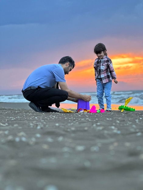 szczęśliwy dzień ojca dla ojca i córki bawiących się piaskiem na plaży