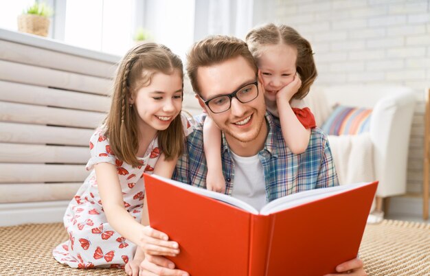 Szczęśliwy dzień ojca Ojciec czyta książkę swoim córkom