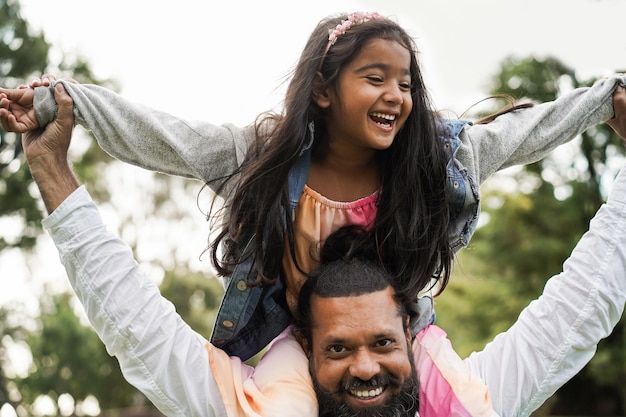 Szczęśliwy indyjski ojciec bawi się z córką na świeżym powietrzu Skup się na twarzy ojca