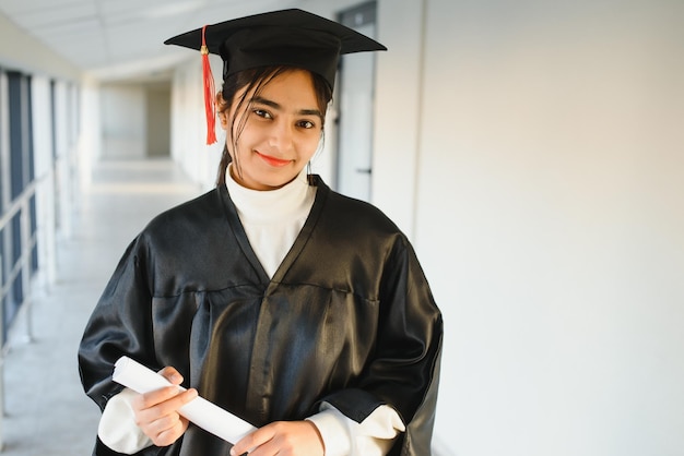 Szczęśliwy Indyjski Student W Sukni Ukończenia Studiów I Czapce, Posiadający świadectwo Dyplomu.